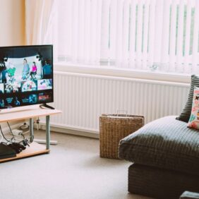 Stijlvol tv-meubel van 210 cm in een moderne woonkamer met bijpassende decoratie en een grote televisie.
