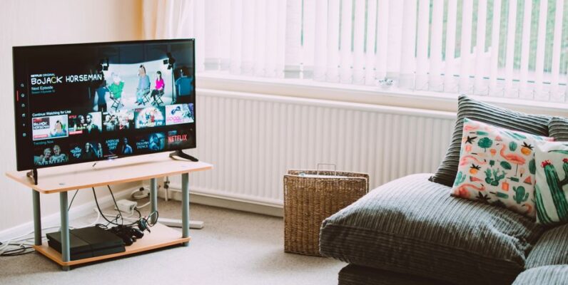 Stijlvol tv-meubel van 210 cm in een moderne woonkamer met bijpassende decoratie en een grote televisie.